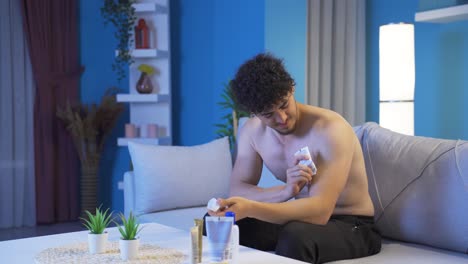 Young-man-applying-treatment-cream-to-his-pain.